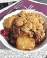 Slice of apple cranberry dump cake with golden butter crust