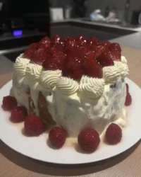 Cake decorating in process showing smooth buttercream on white cake layers