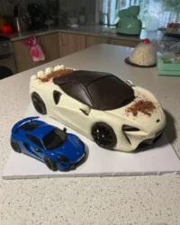Finished red car cake shaped like a beetle on a road board