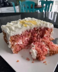 Classic Southern strawberry cake with a pink crumb and cream cheese frosting on a cake stand