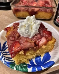 Slice of fresh strawberry sheet cake with pink frosting on a white plate
