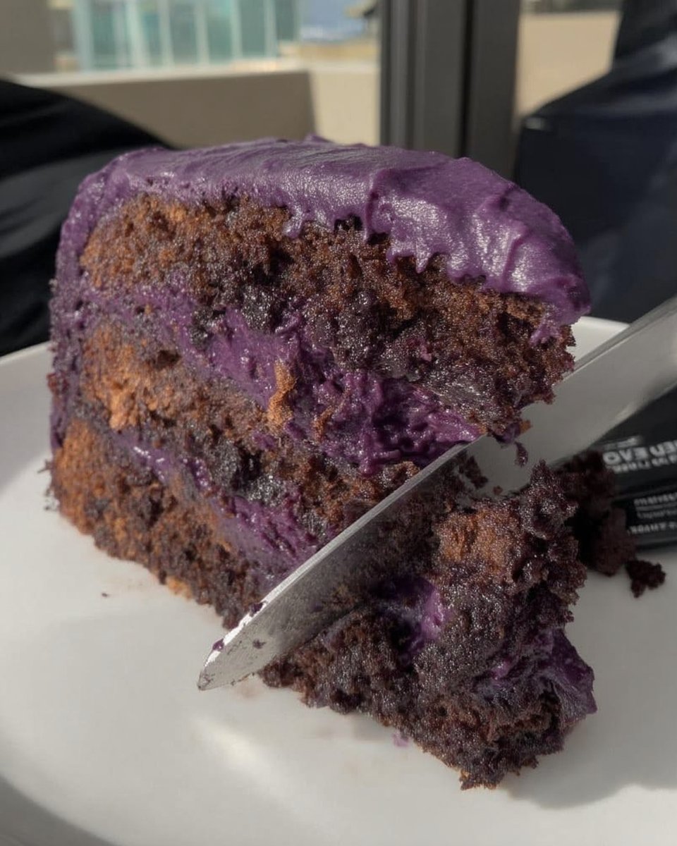 Whole purple cake frosted with cream cheese icing and lemon zest
