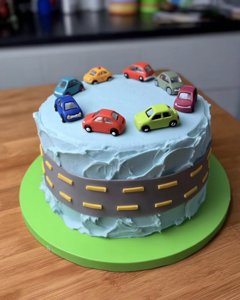 Boy Cake 13 Smoothing blue buttercream on a cake using a bench scraper