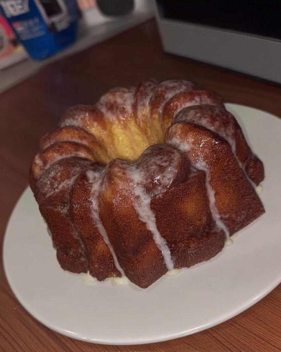 Slice of glazed lemon pound cake served on a white plate with a fork
