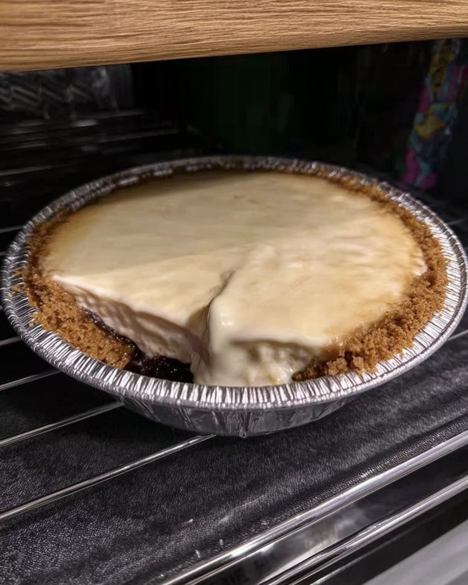 Cheesecake pan wrapped in foil inside a roasting pan with water
