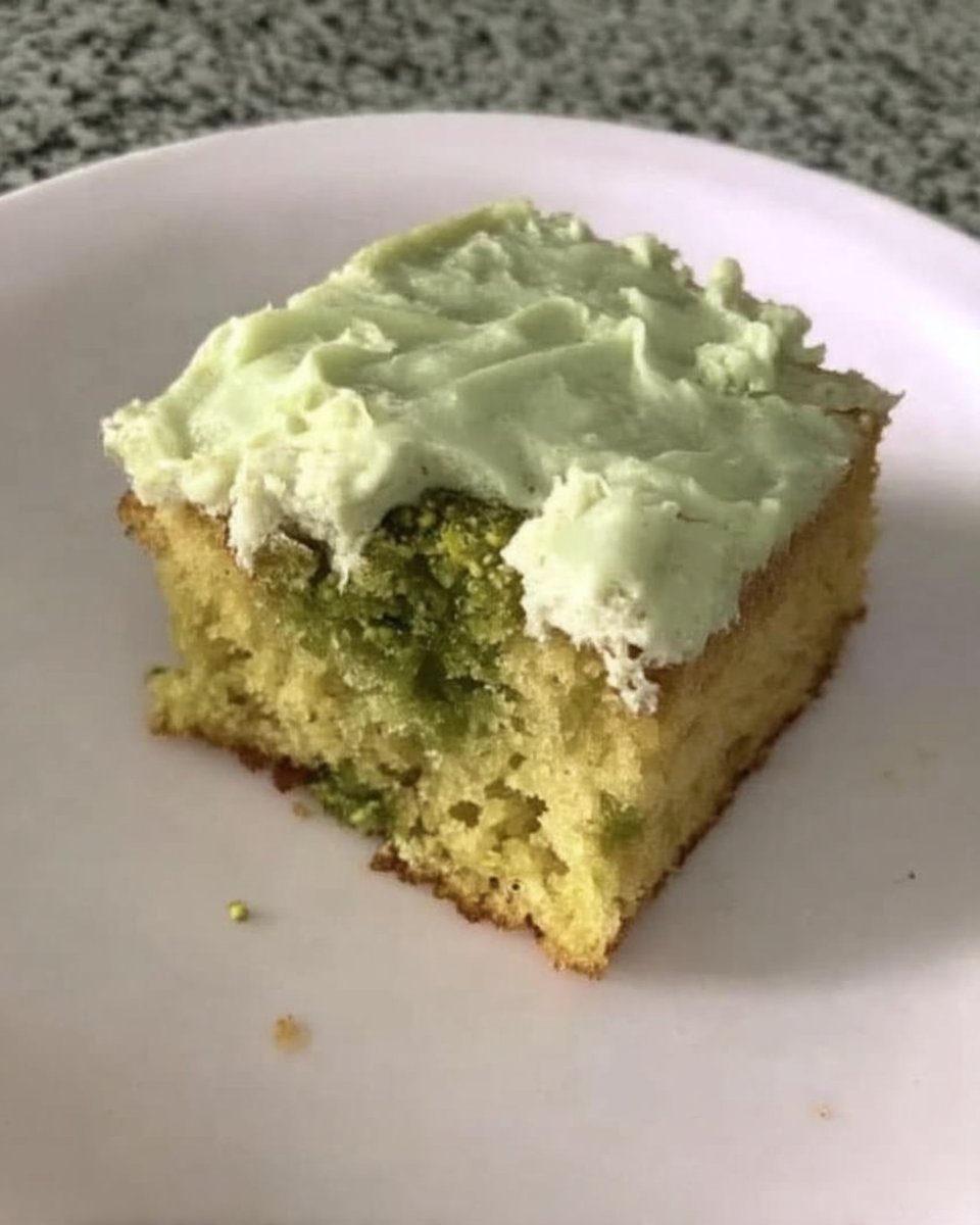 Watergate Cake 13 Green pistachio cake batter being mixed in a bowl with a spatula