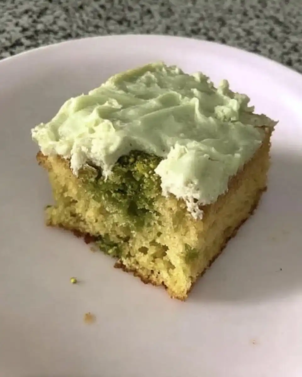 Watergate Cake 13 Green pistachio cake batter being mixed in a bowl with a spatula