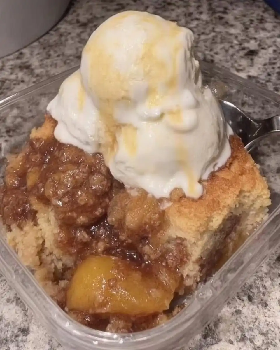 Thick peach cake batter in a mixing bowl with spatula