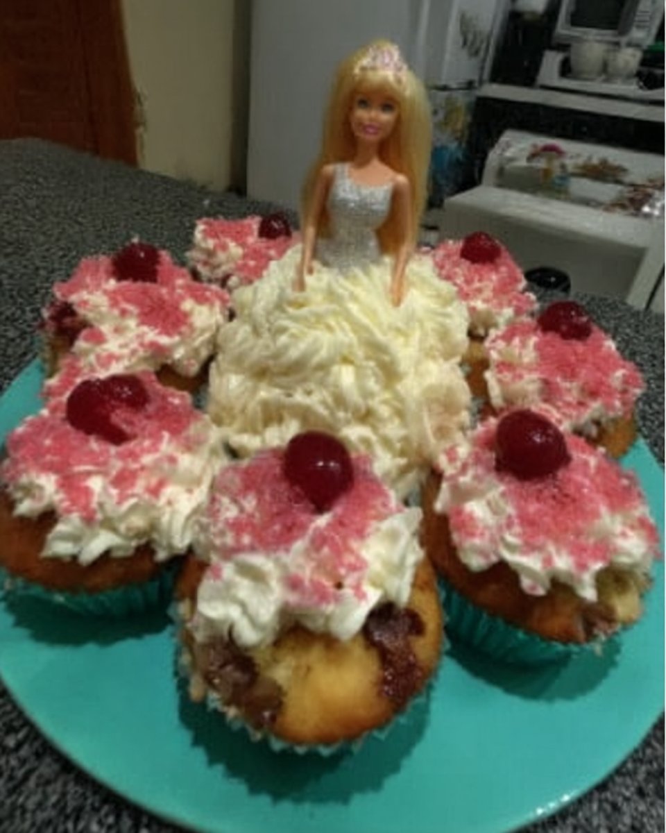 Green marzipan being draped over a dome shaped cream cake