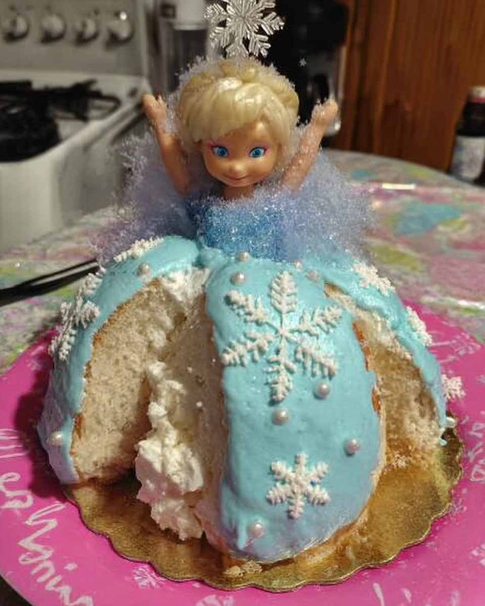 Whole green princess cake on a white ceramic serving stand