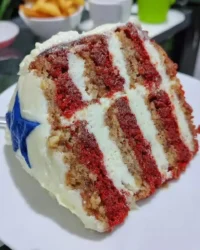 Red white and blue cake decorated with fresh strawberries and blueberries on a rustic table
