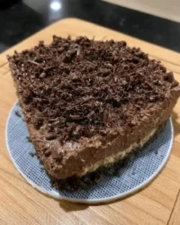 Slice of rich chocolate cheesecake on a handmade ceramic plate