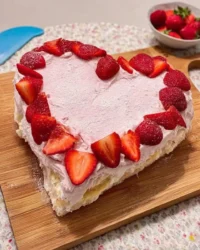 Rustic valentines cake shaped like a heart with pink strawberry frosting