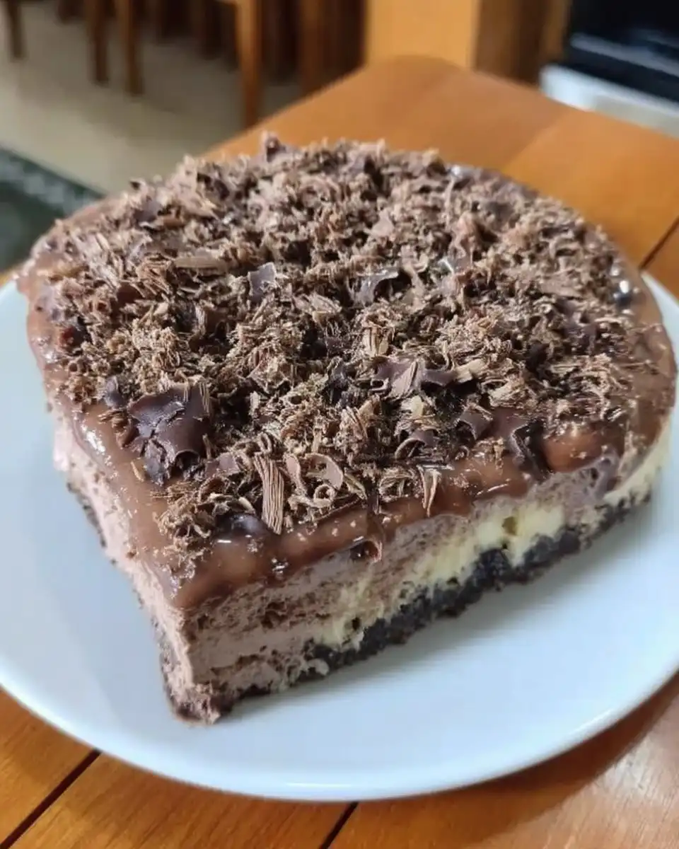 Whole chocolate cheesecake with ganache being poured over it