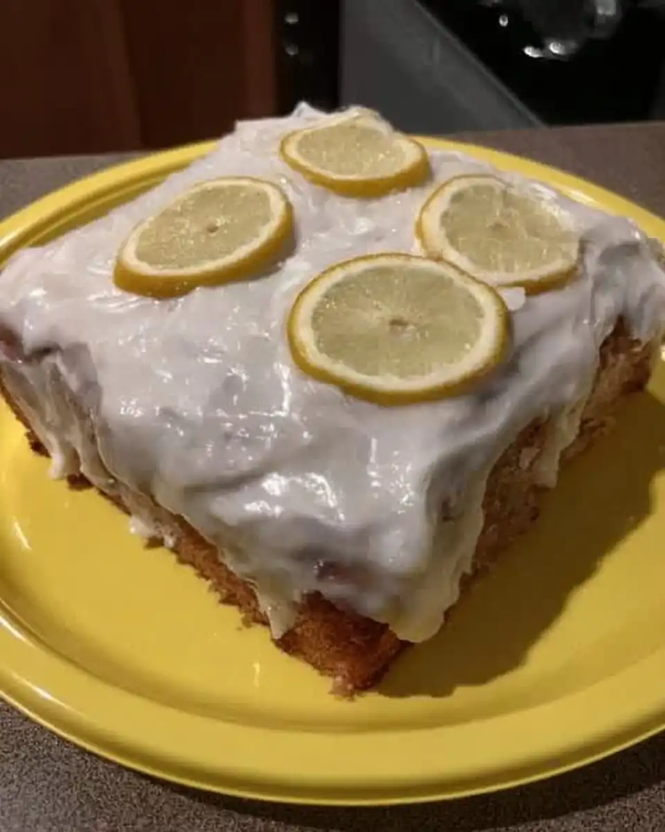 Lemon Cake 10 Slice of moist lemon cake on a white plate with a fork