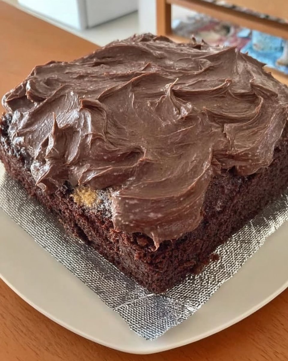Slice of wacky cake depression cake on a white plate showing moist dark crumb
