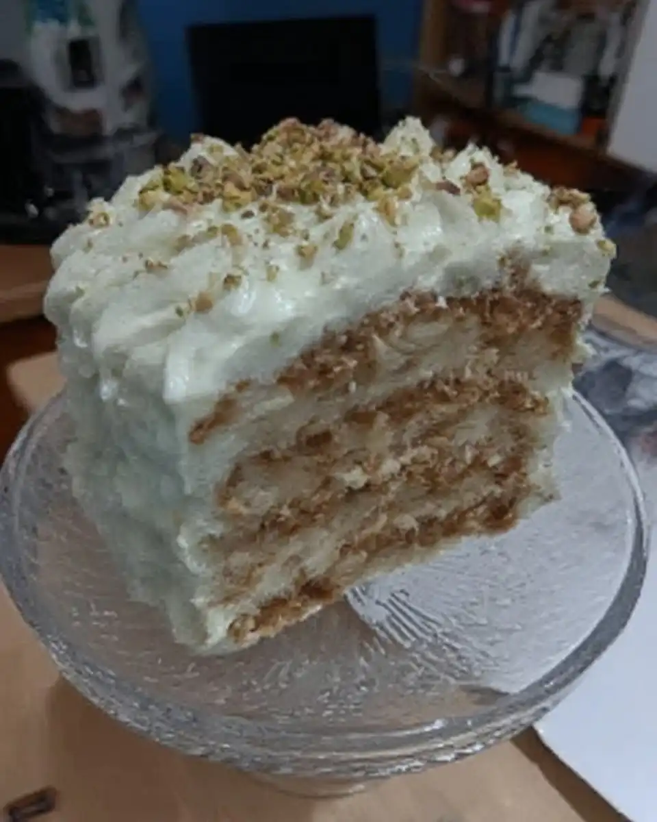Watergate Cake 10 Slice of green watergate cake with whipped topping and pecans on a white plate