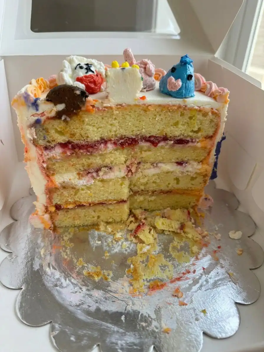Ateco 844 tip piping purple frosting swirls on top of a cake