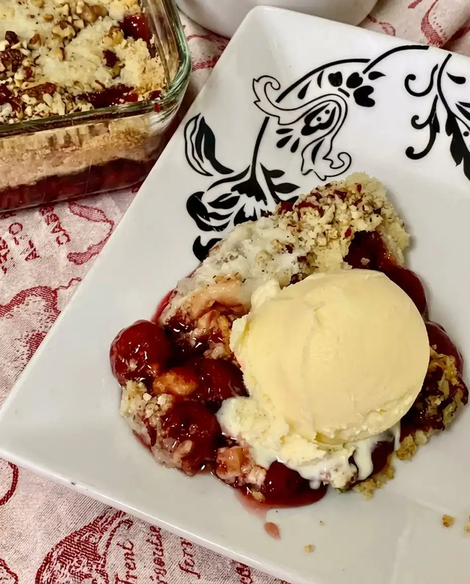 Cherry Dump Cake 13 Close up of thin butter slices arranged in a grid pattern over a layer of dry cake mix and pecans.