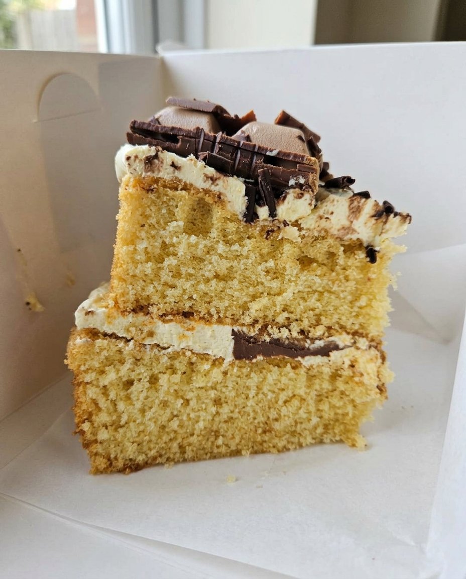 A hand inserting a wooden skewer into a rectangular cake in a baking dish.