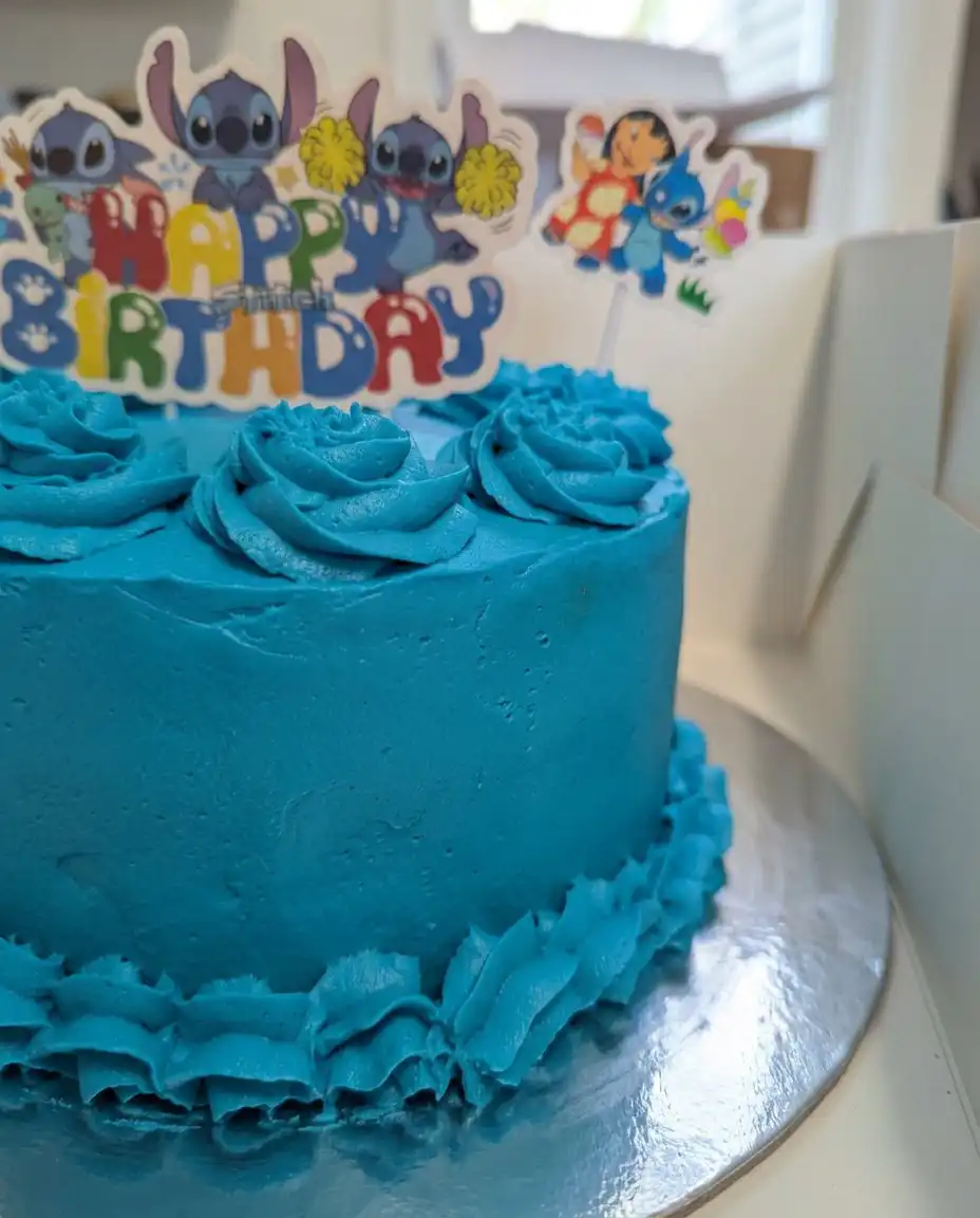 A completed Stitch Cake with rustic buttercream swirls and cherries on a ceramic plate.