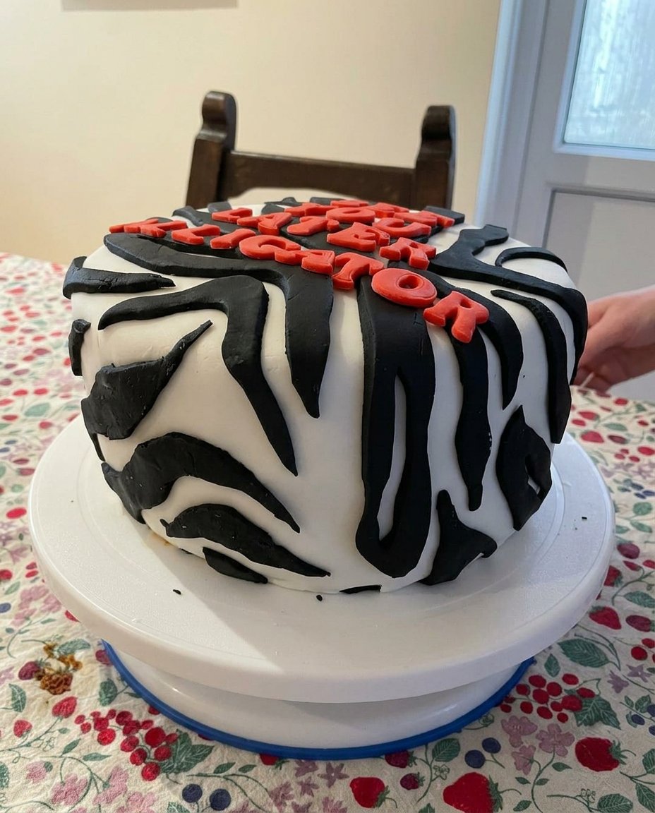 A finished aesthetic cake with pink vintage piping and a smooth top