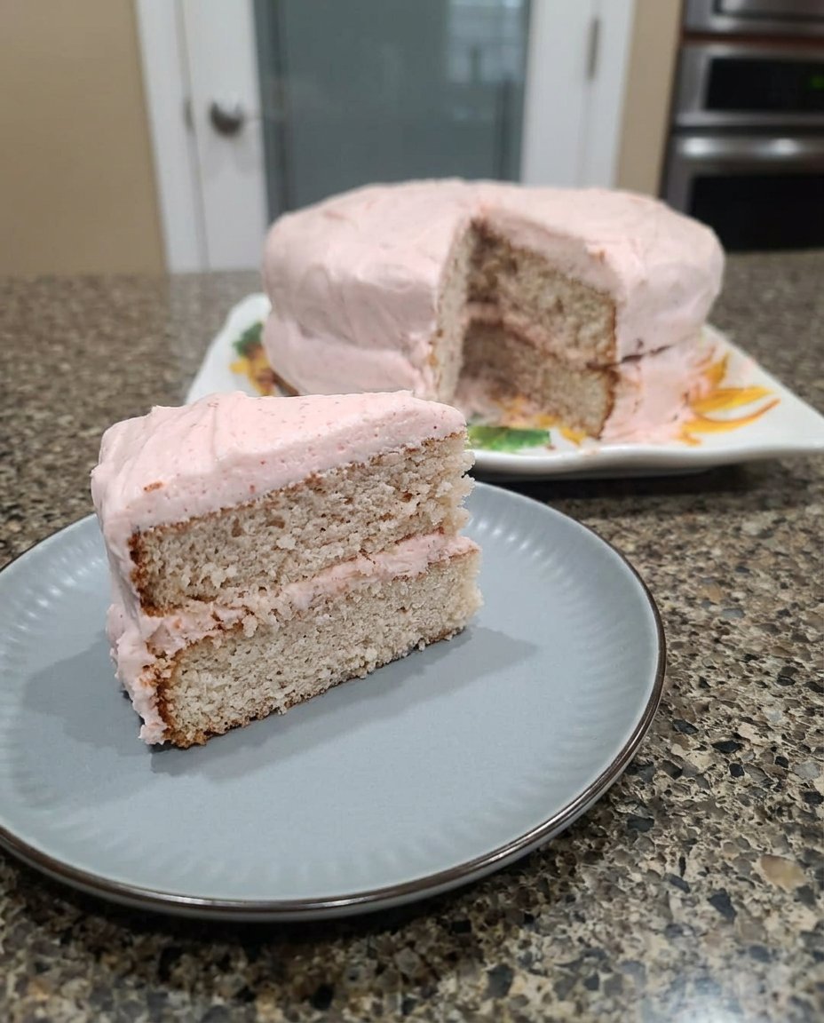 Close up of a fork pulling away a piece of moist strawberry cake showing the internal texture