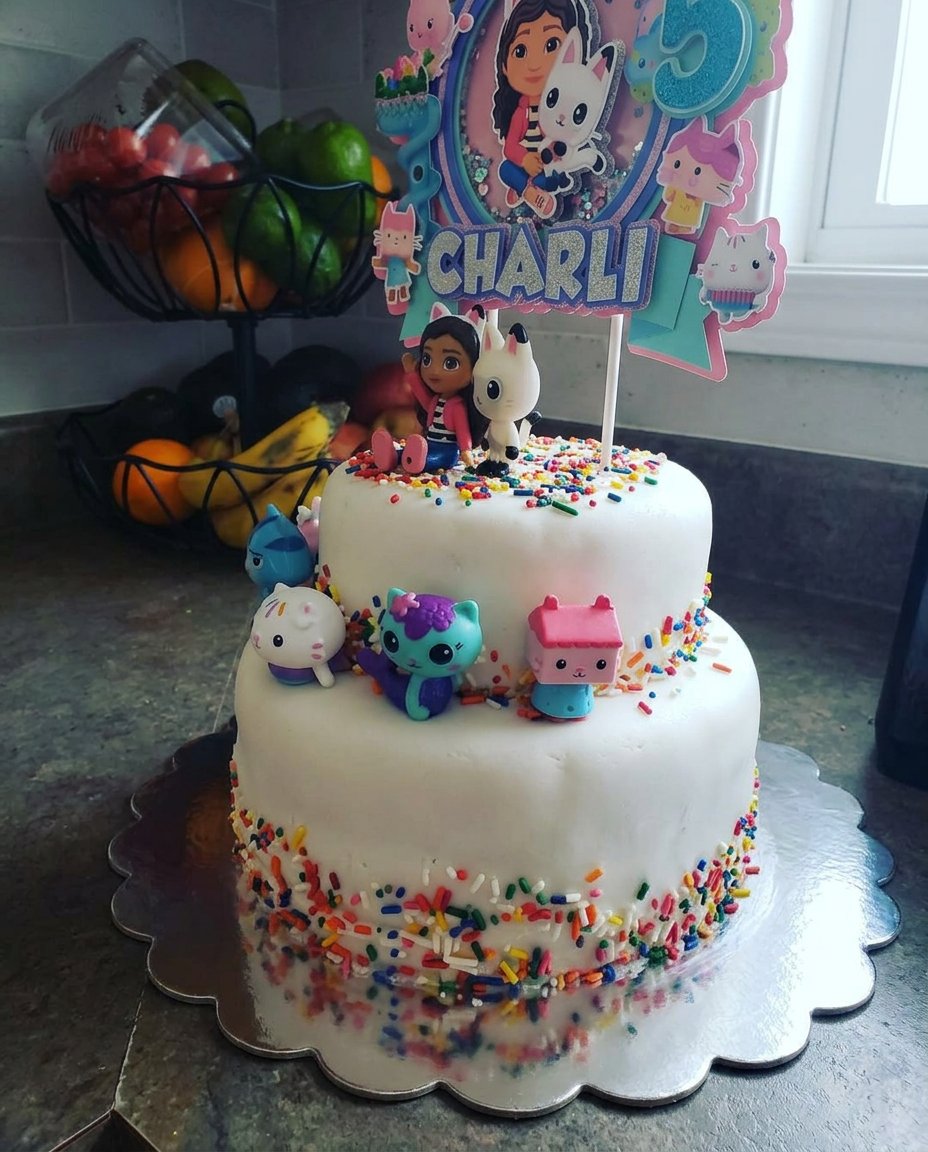 A fluffy vanilla buttermilk cake decorated with pink frosting and sprinkles