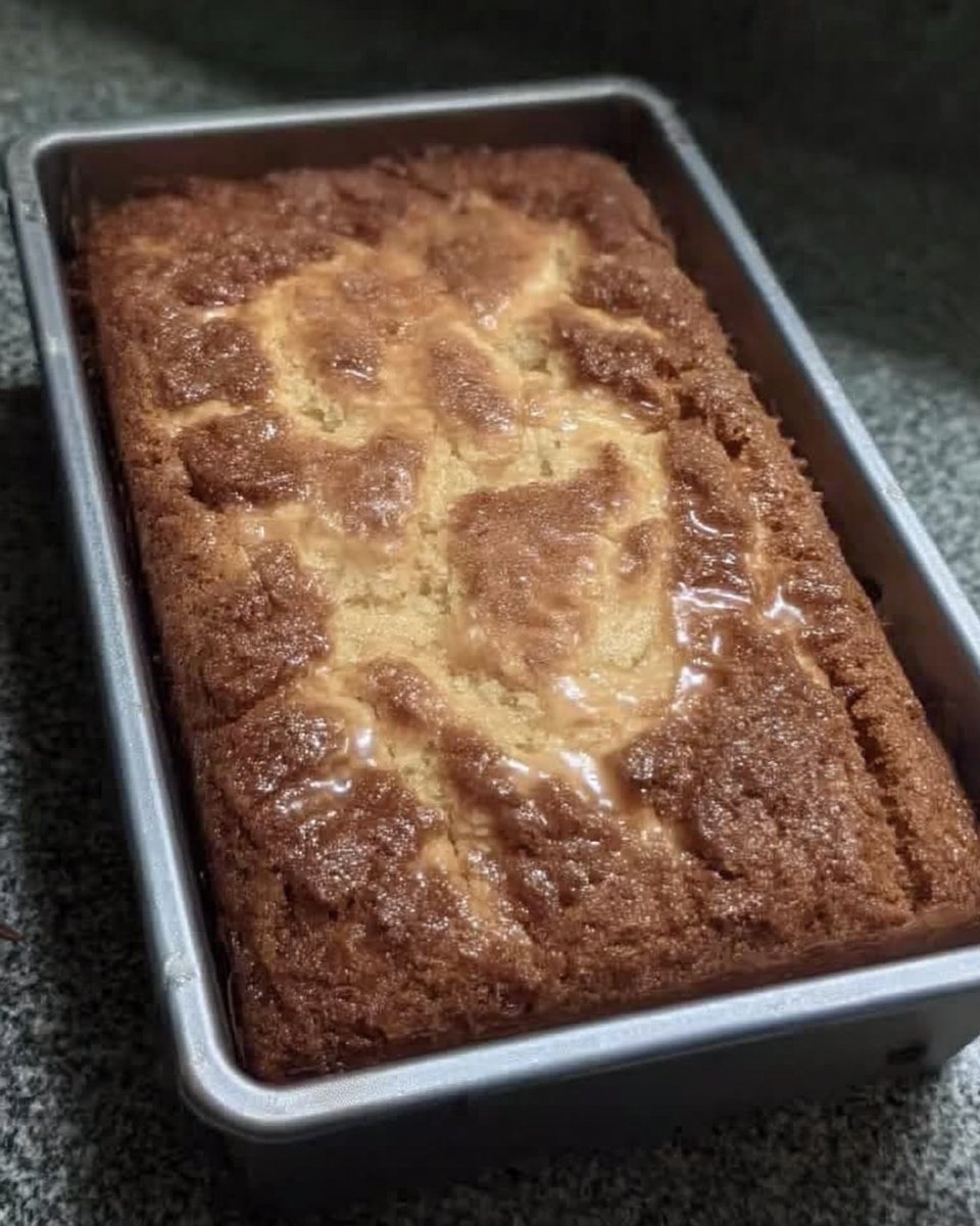 Several squares of ooey gooey butter cake stacked on a white ceramic plate with fresh berries.
