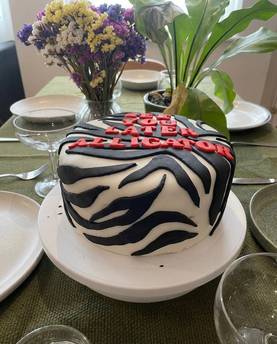 A hand piping intricate buttercream ruffles onto a yellow cake layer