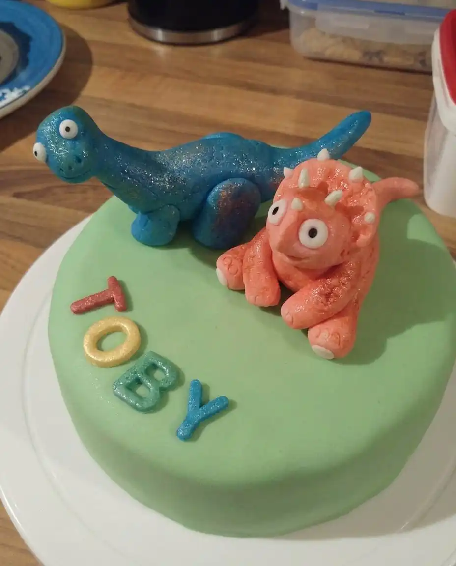 Close up of a grass nozzle piping green buttercream onto a cake