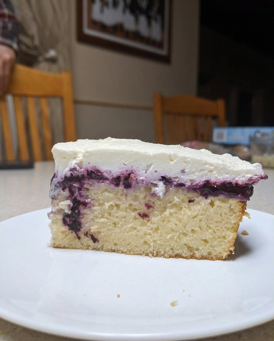 A hand using a wooden spoon handle to poke holes into a warm golden cake.