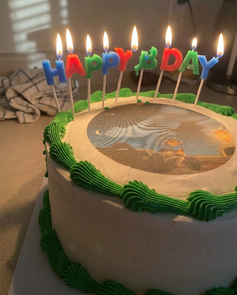 A professional photo cheesecake sitting on a white ceramic stand with a beautiful edible image on top.