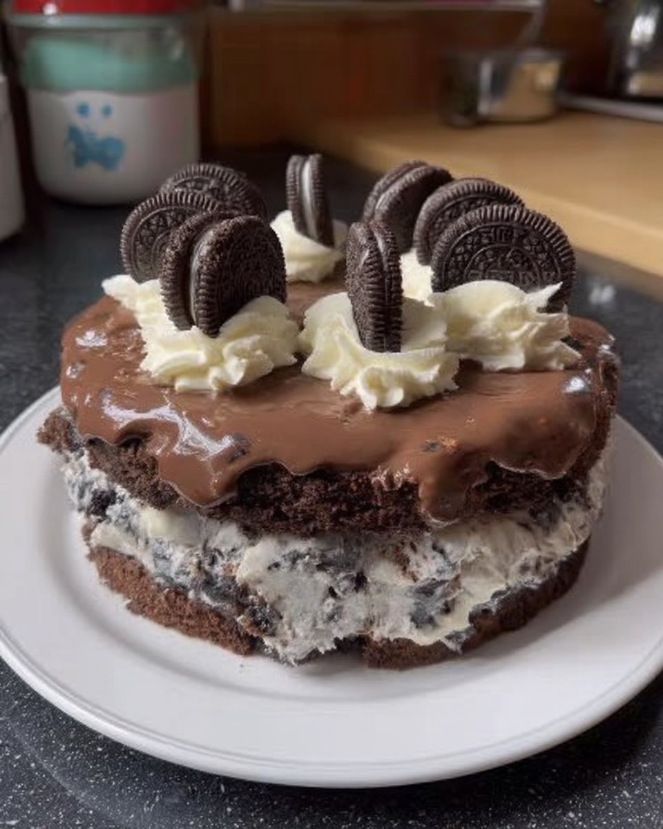 A three layer Oreo cake with chocolate ganache drips on a rustic wooden table