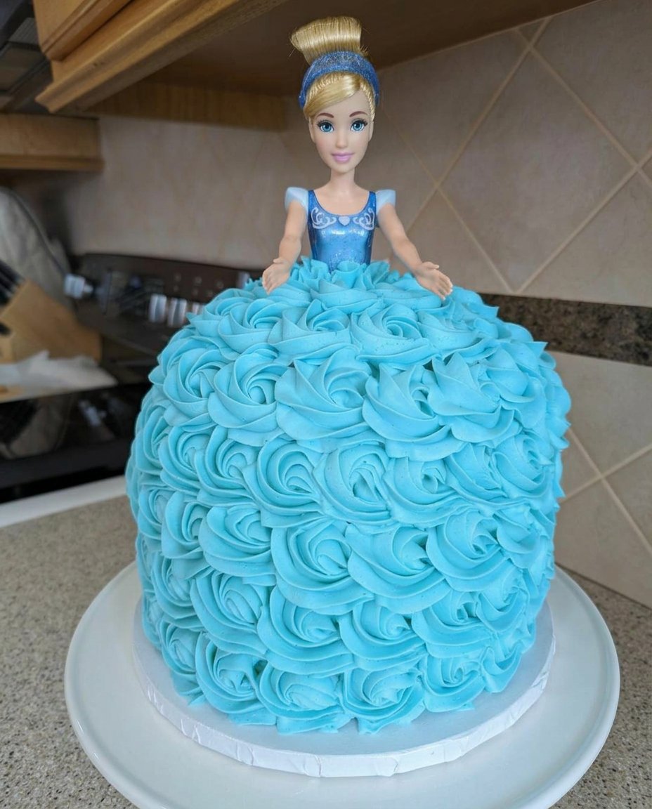 Cinderella Cake 14 A slice of white cake with blue frosting rosettes served on a rustic plate