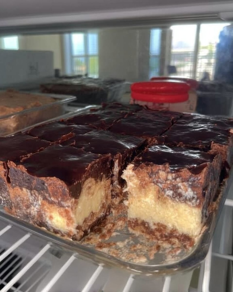 A square slice of chocolate eclair cake on a white plate with a fork