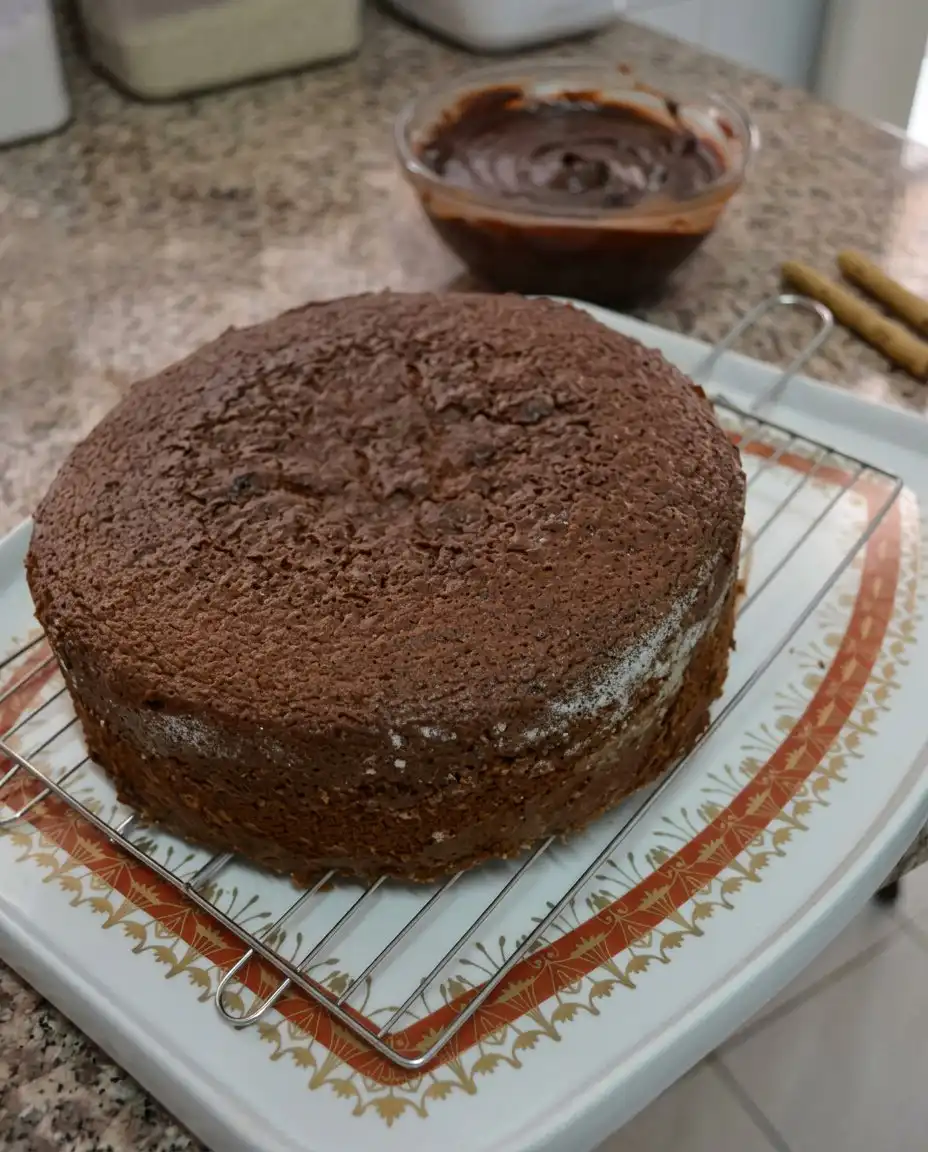 A single slice of chocolate cake with ganache on a rustic ceramic plate