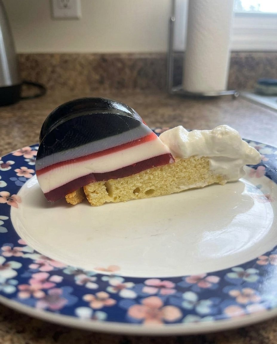 Jello Cake 13 A slice of jello cake showing the internal strawberry and cream layers.