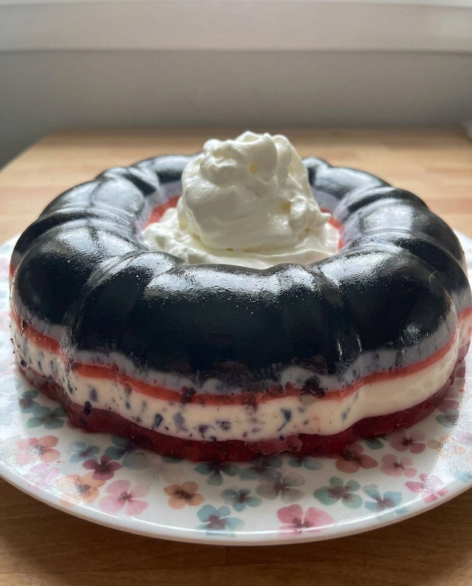 Jello Cake 14 Serving a slice of strawberry jello cake on a glass plate with mint.