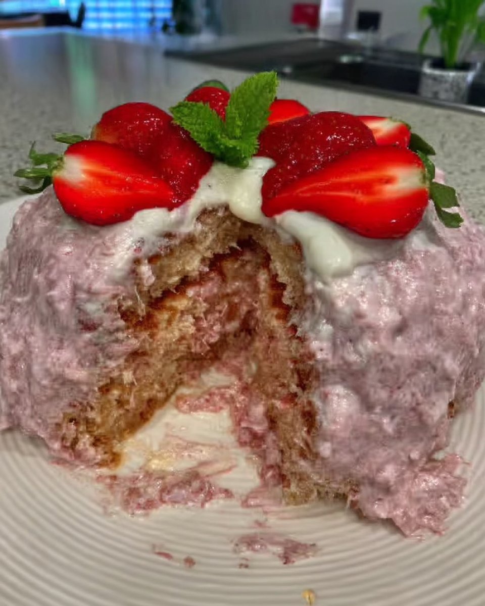 A thick dark red strawberry reduction in a glass bowl used for flavoring cake and frosting.