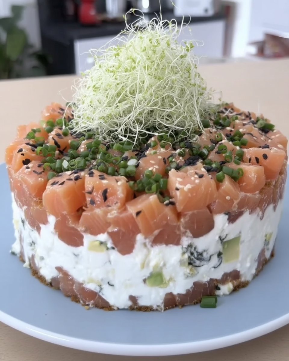 A close up of a sushi cake showing defined layers of rice salmon and avocado