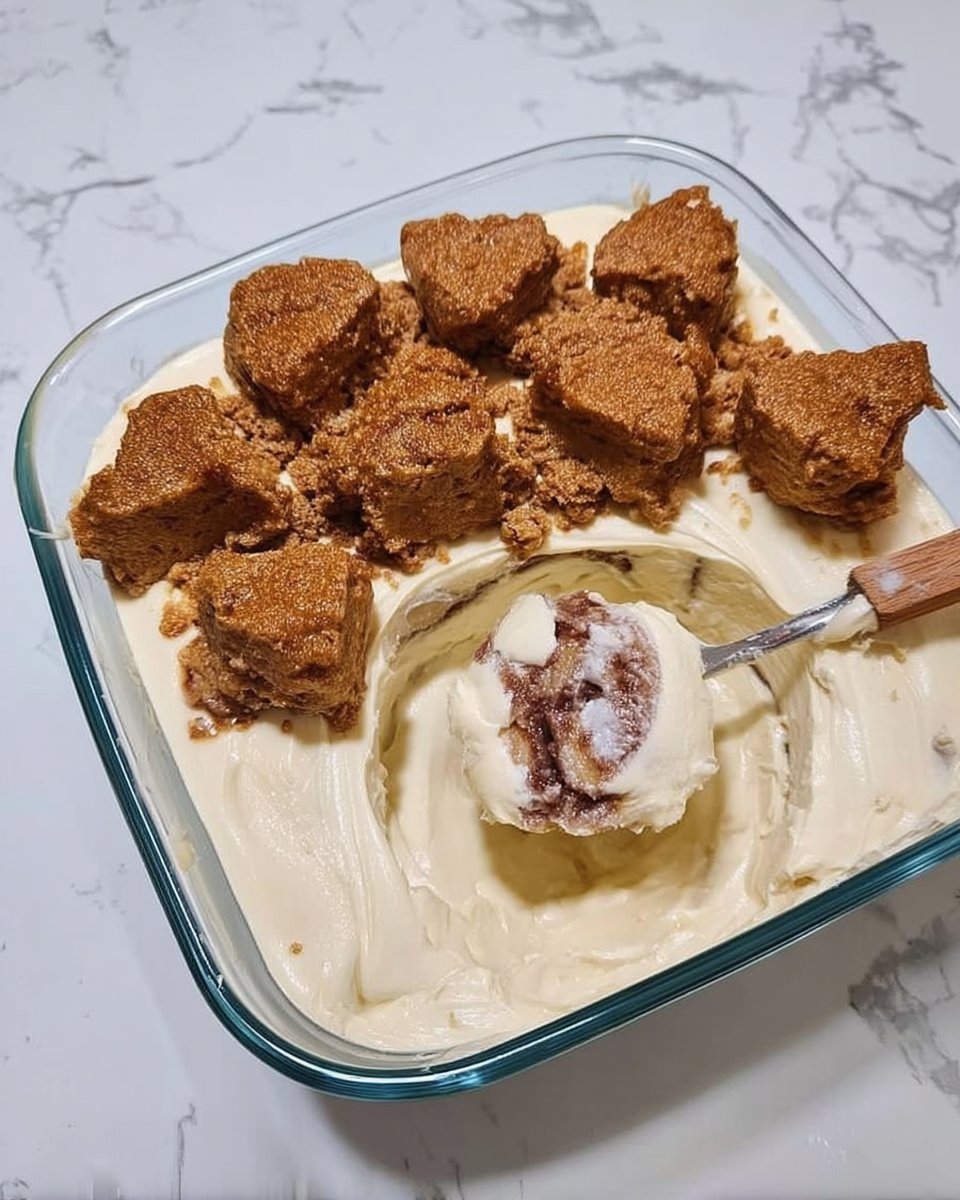 A hand using a knife to swirl cinnamon sugar mixture into yellow cake batter.