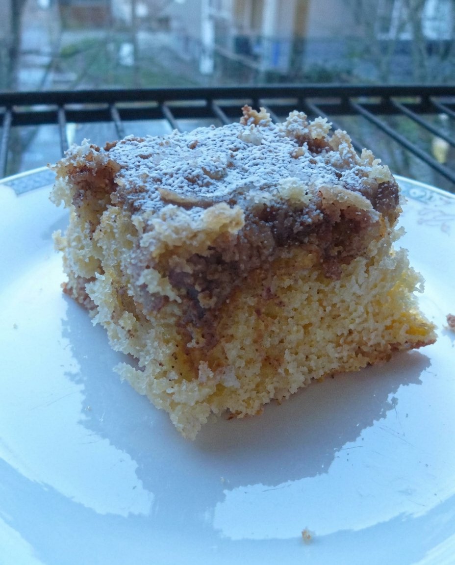 A knife swirling creamy custard into yellow cake batter in a baking dish