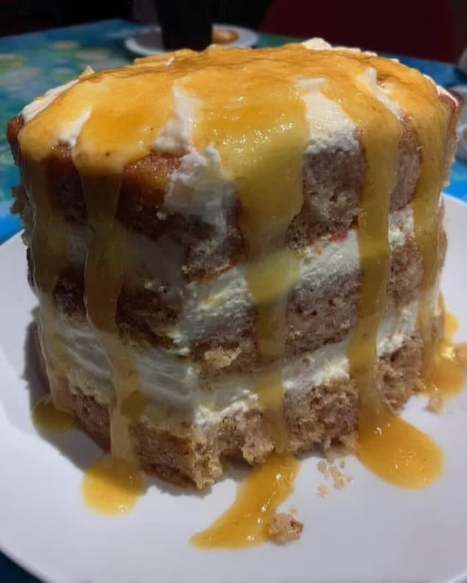 A slice of Lemon Rainbow Cake 2 showing yellow, orange, and green citrus layers with white frosting.