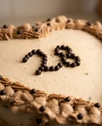 A beautiful heart shaped cake with pink cream cheese frosting and shell borders.