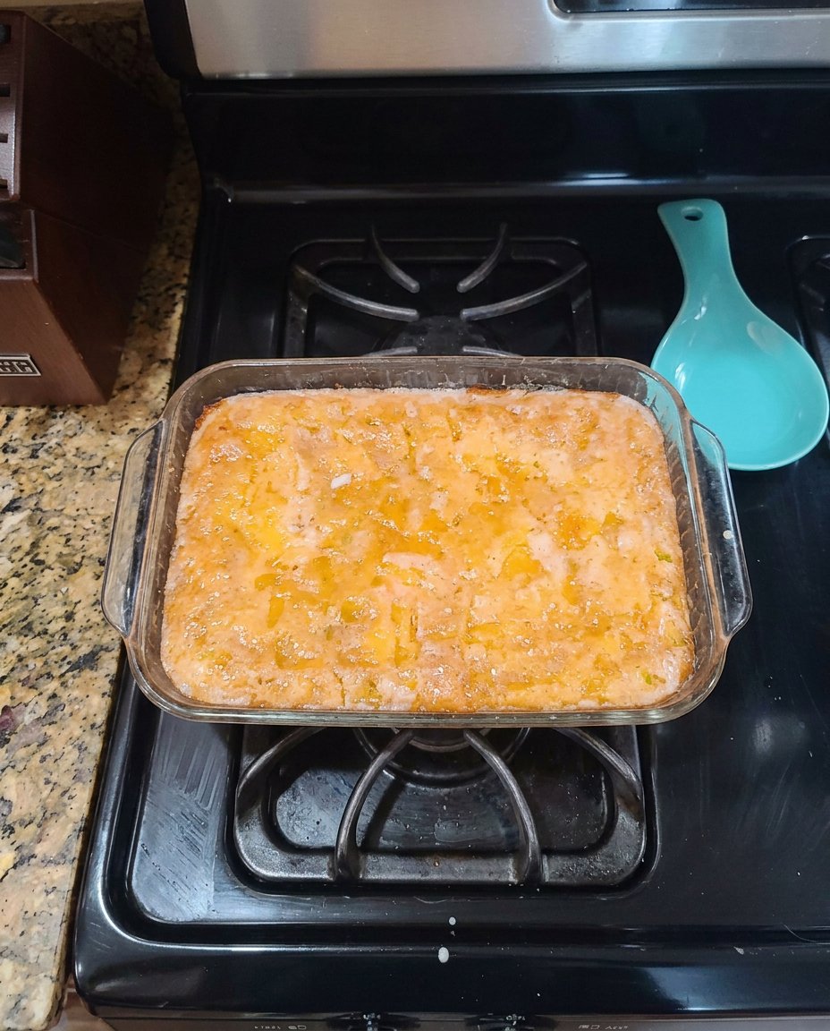 Baking ingredients including yellow cake mix, fresh lemons, eggs, and applesauce on a kitchen counter