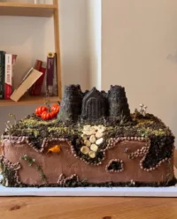 A large homemade castle cake with pink turrets and marshmallow decorations
