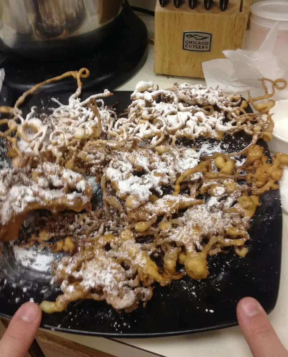 Funnel Cake Recipe 13 A candy thermometer clipped to the side of a pot of oil reading exactly three hundred and seventy degrees.