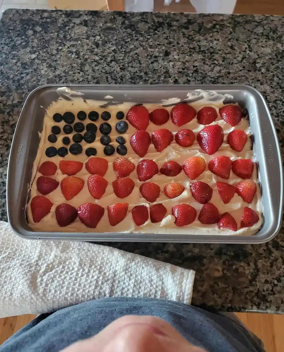 A single slice of American flag cheesecake showing the creamy layers and fruit topping.