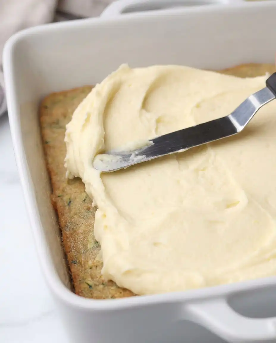 A pan of Zucchini Bars inside a preheated oven showing the golden brown edges.